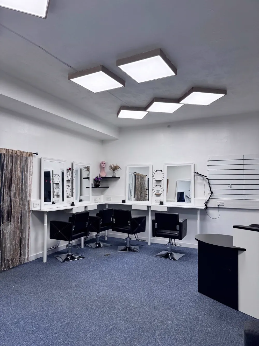 Inside ONOMZ Beauty Salon Aberdeen, styling stations with mirrors and black salon chairs